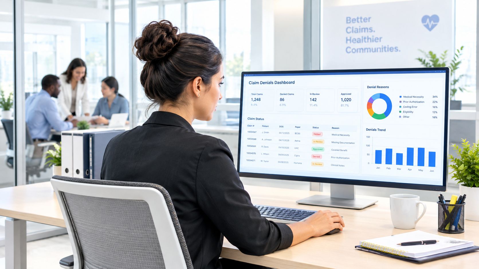 A professional woman working at a computer displaying a healthcare claim denials dashboard in an office.